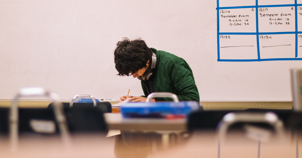 High school senior sitting alone and studying at school