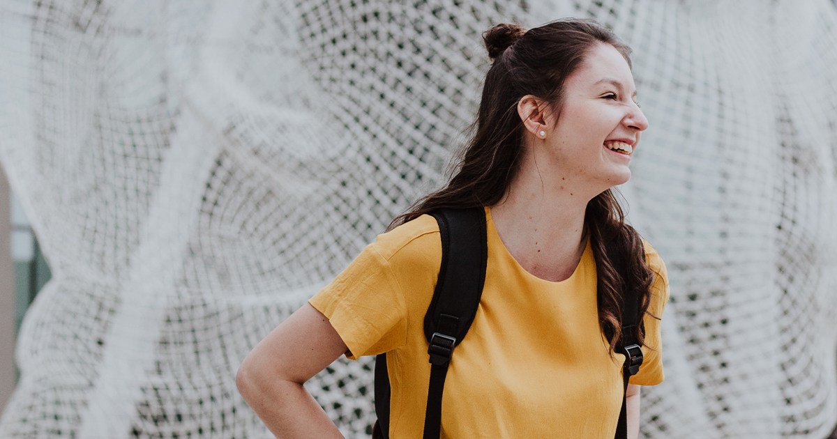 College student wearing yellow shirt smiling